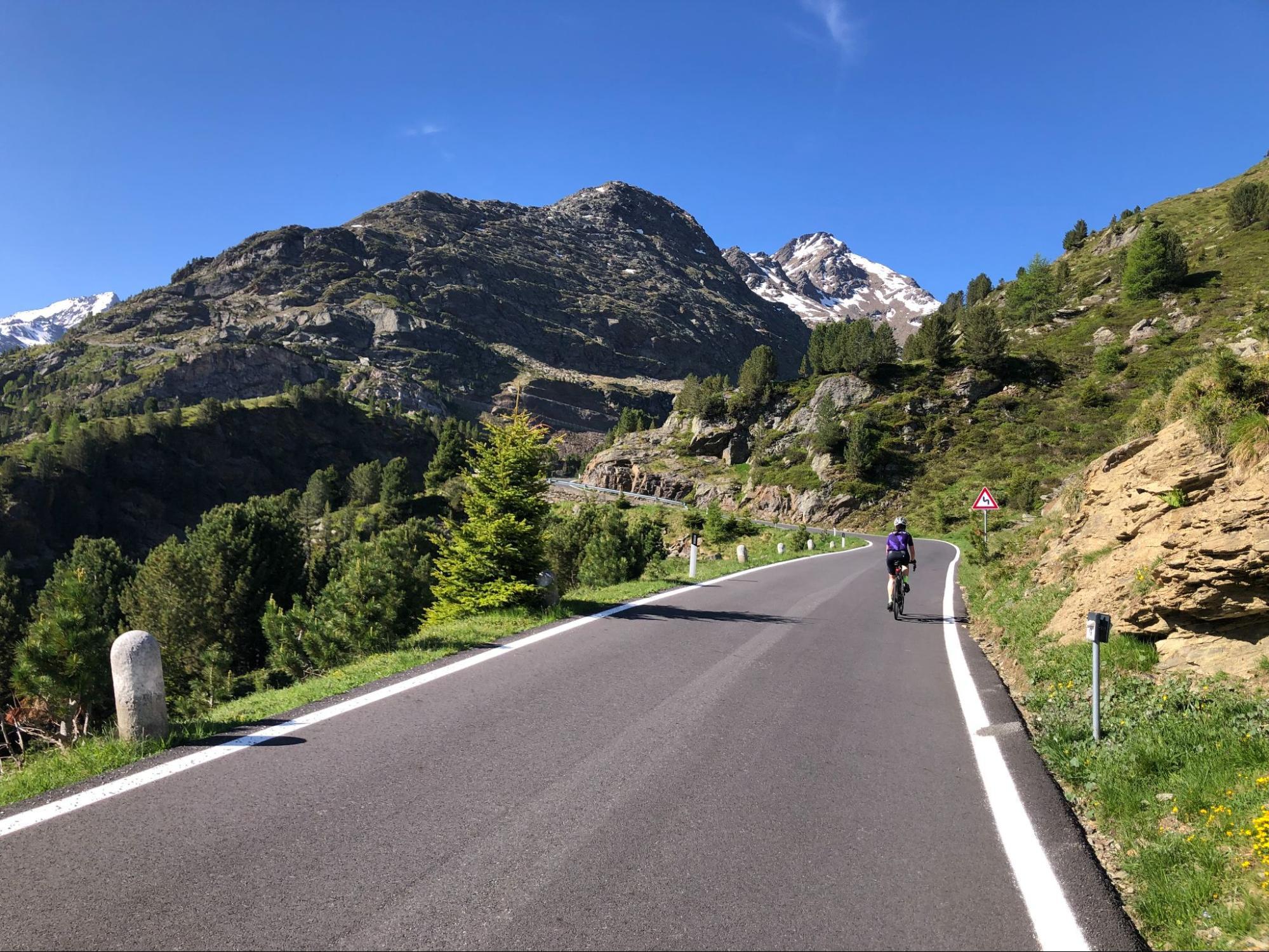 Cyclist climbing a mountain road, showing why climbing matters when choosing a cycling event