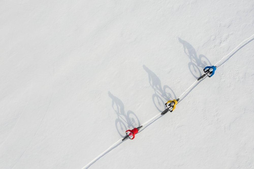 cyclists riding across a snowy area.jpeg