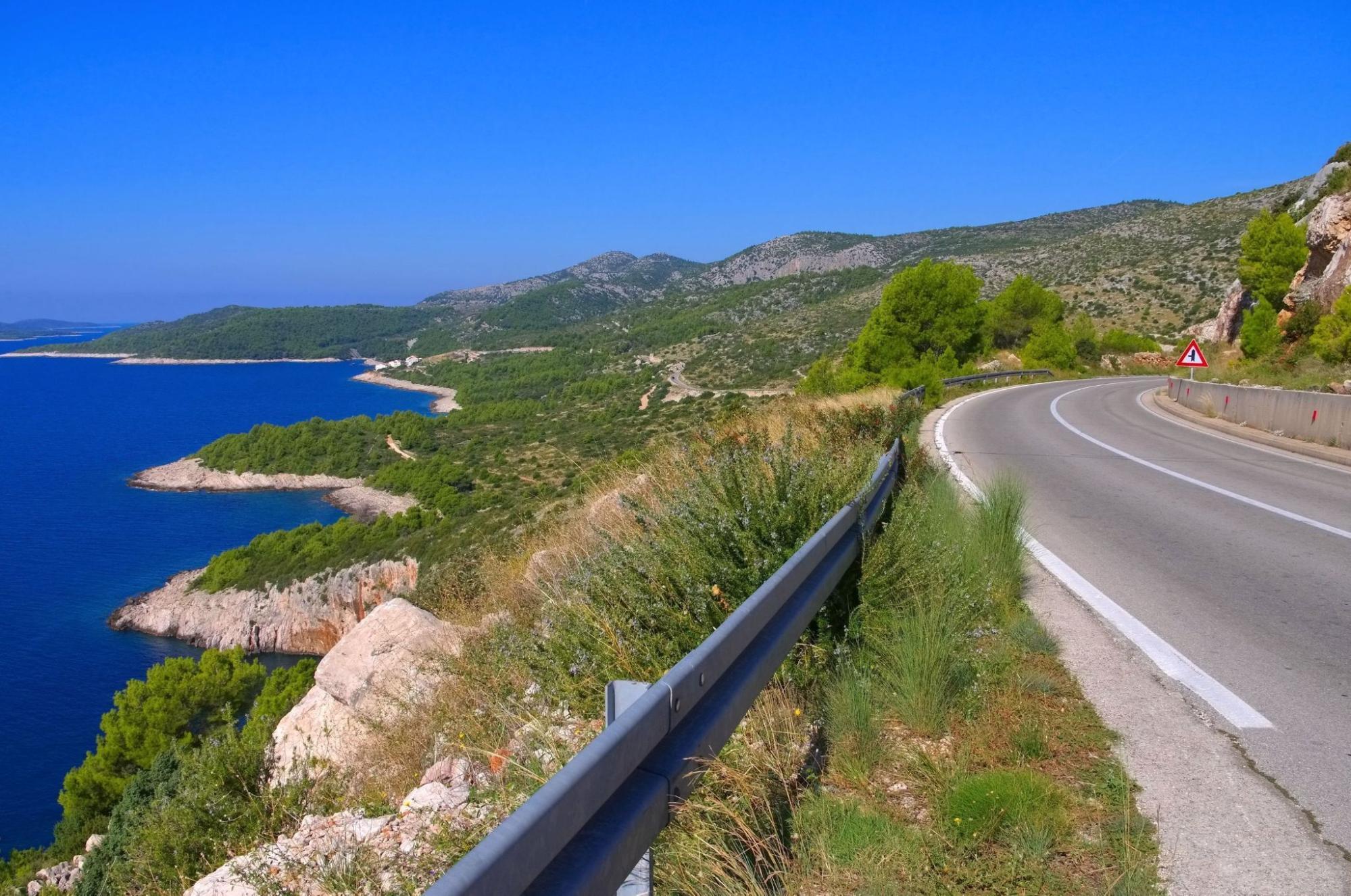 Cyclist on a Croatian island road with wide views over the Adriatic